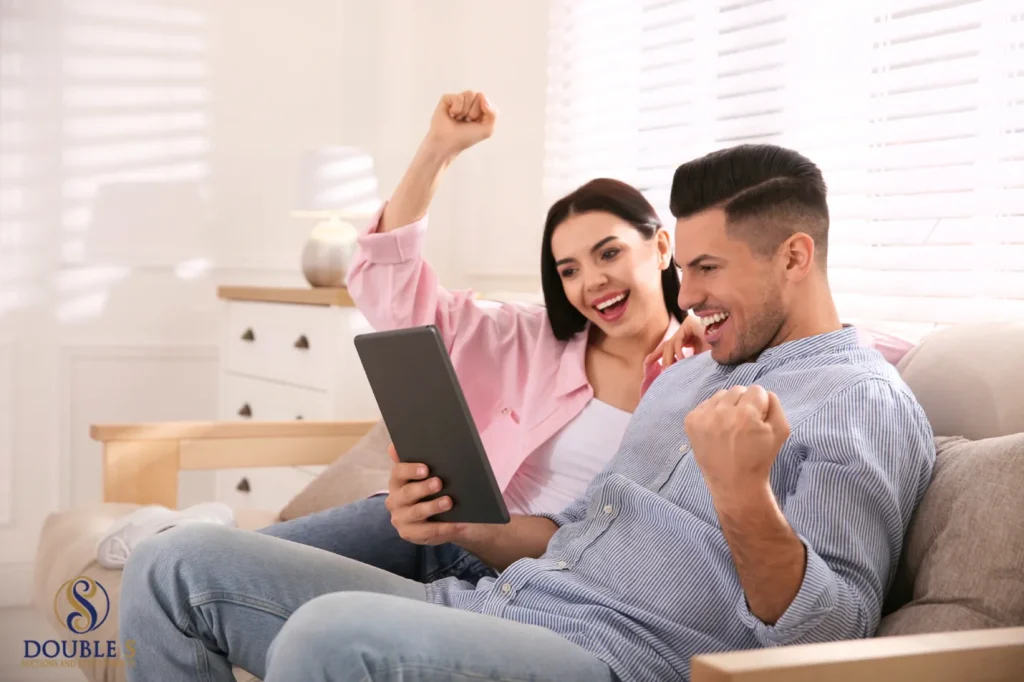 A man and woman sit on a couch, celebrating their successful auction experience in Amarillo, Texas