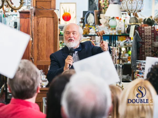Auctioneer holding a gavel during a live estate sale by Double S Auctions in Amarillo TX